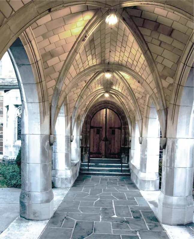 Finished ribbed-vault stone arcade leading to a timber door.