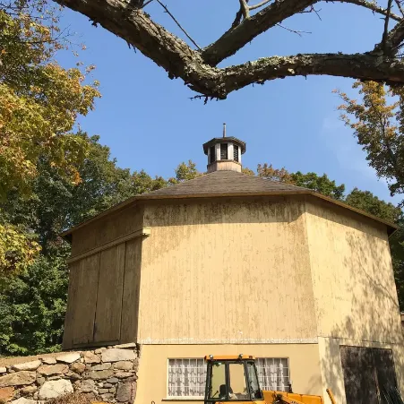 Octagonal barn with a cupola above a fieldstone foundation