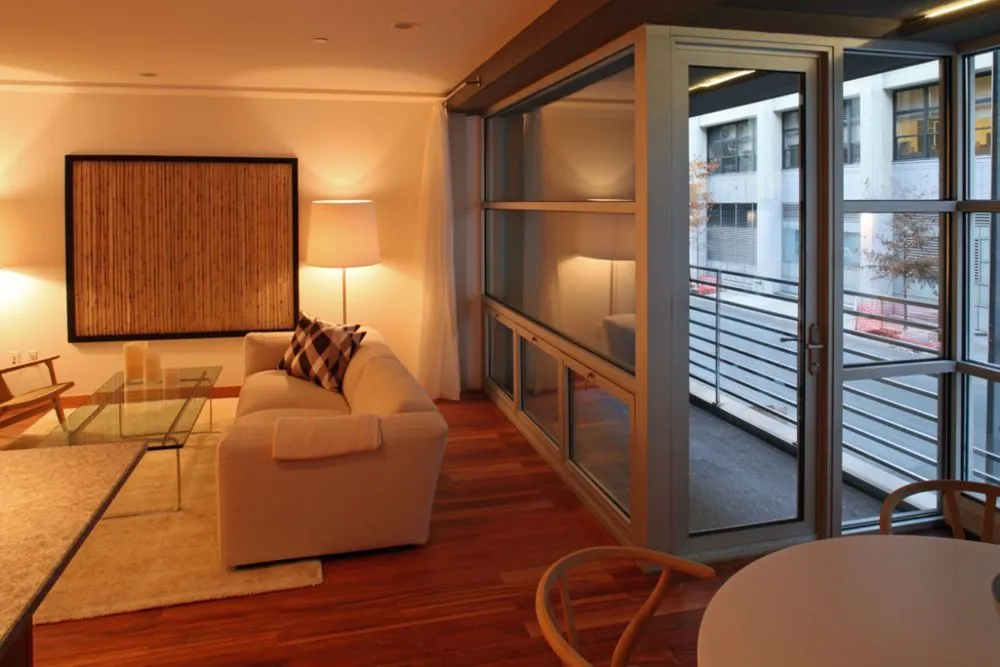 Apartment living room with a sofa and floor-to-ceiling glazing onto a balcony