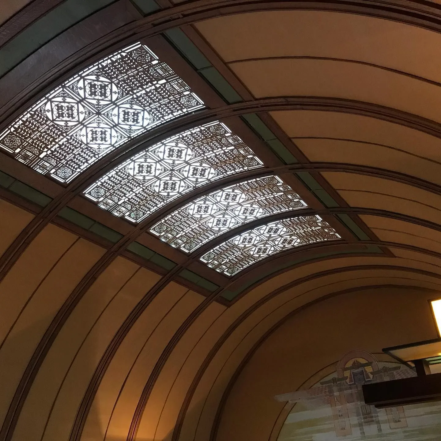 Curved wood ceiling with patterned art-glass panels