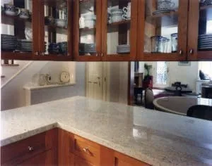 Cherry kitchen cabinets with glass doors above a granite countertop