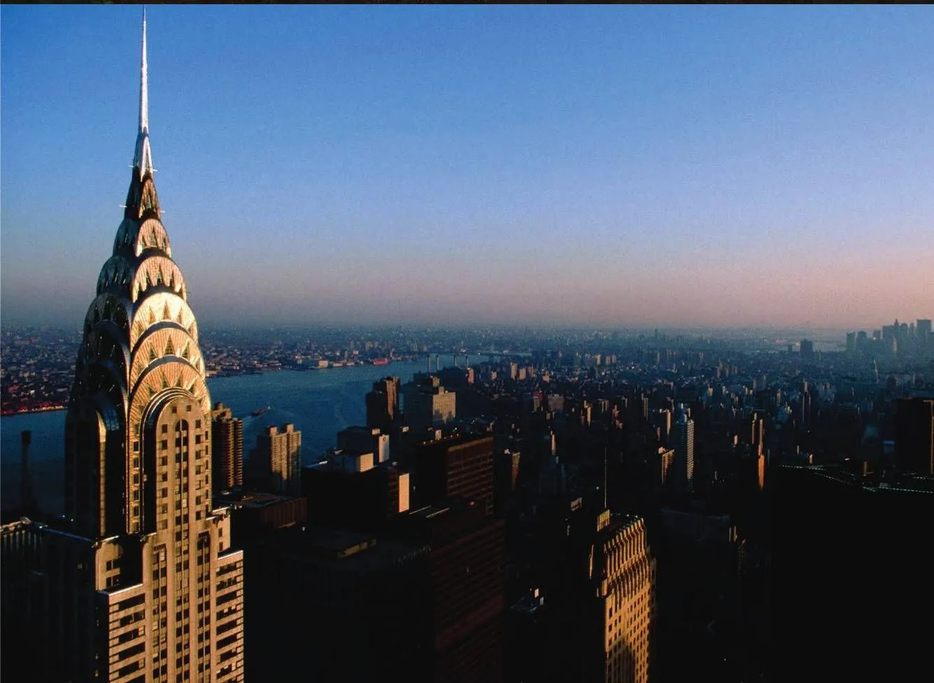 Chrysler Building spire above Manhattan and the East River at dusk