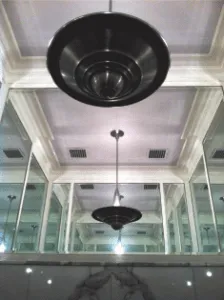 Glass-walled interior with tiered pendant lights beneath a coffered ceiling