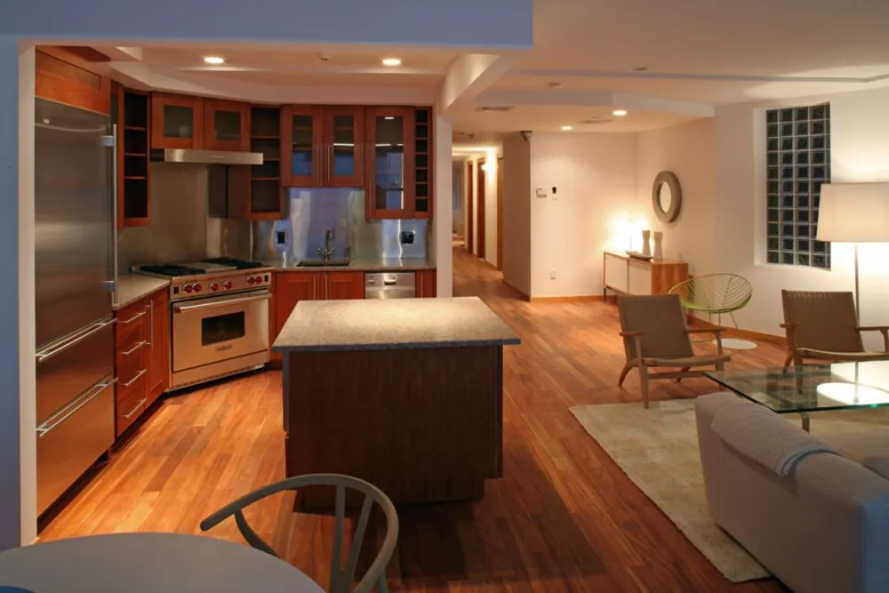 Open loft kitchen with cherry cabinets and an island flowing into the living area