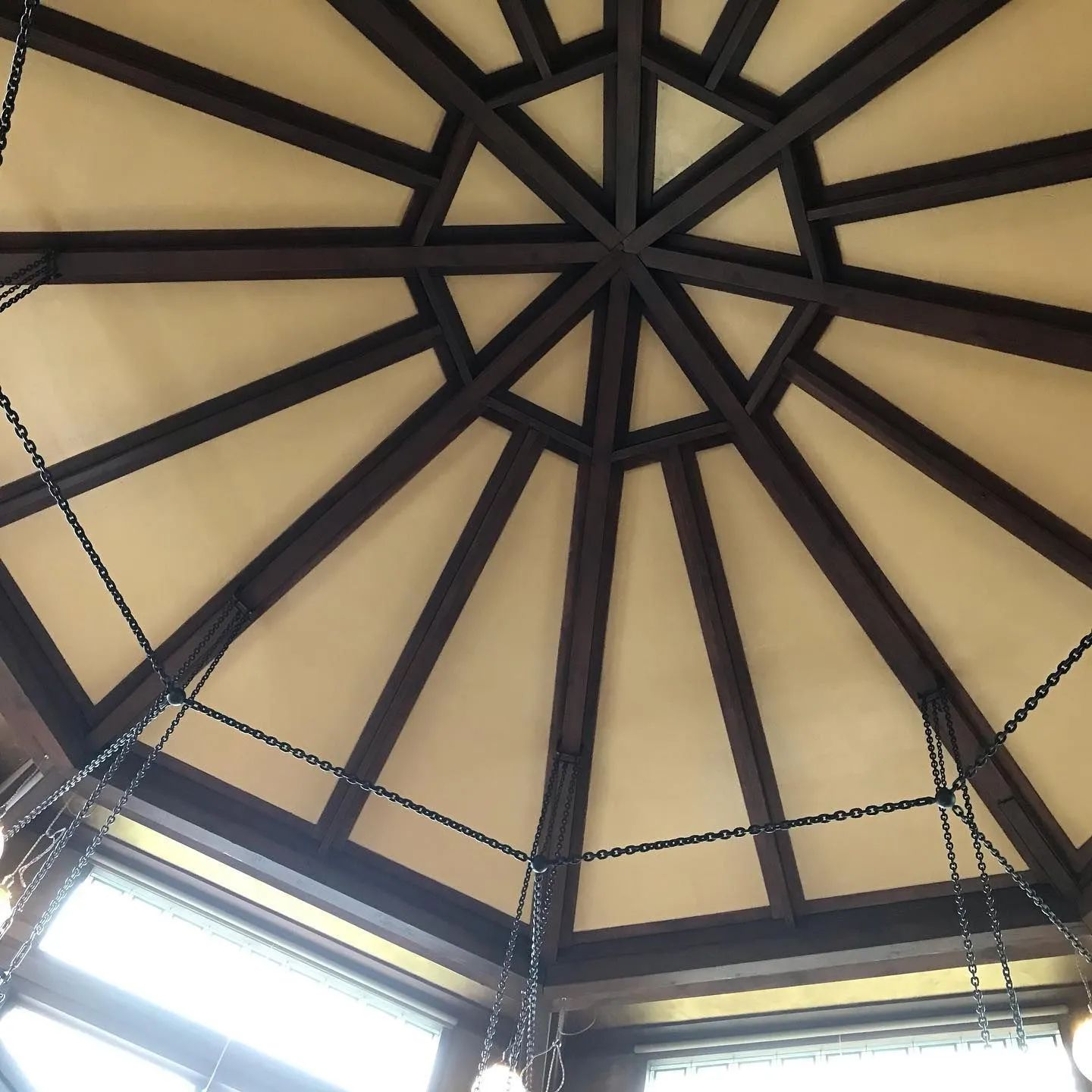 Octagonal ceiling of dark timber beams radiating from a central hub